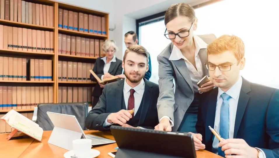 Advogados analisando documentos entre estantes